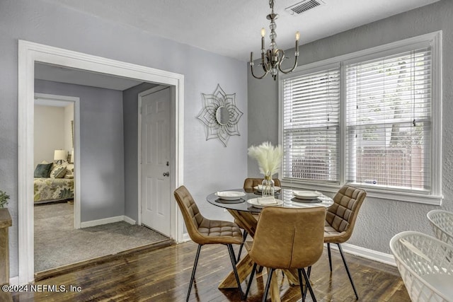 dining area with an inviting chandelier, baseboards, visible vents, and wood finished floors