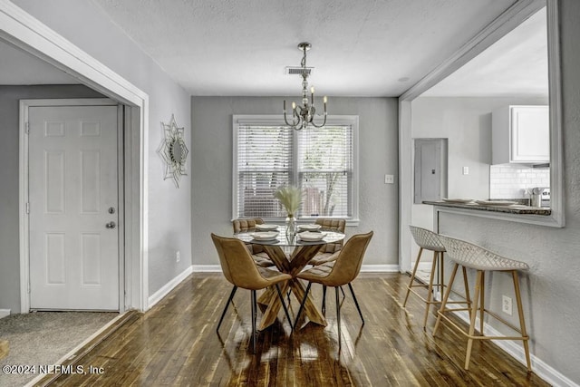 dining room featuring dark wood-type flooring, electric panel, baseboards, and an inviting chandelier