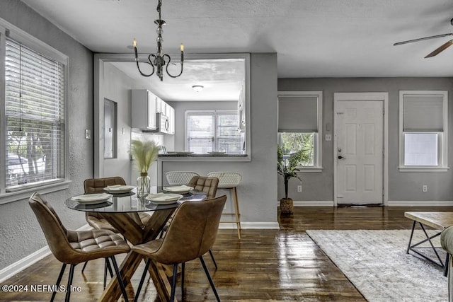 dining room with baseboards, wood finished floors, and a textured wall