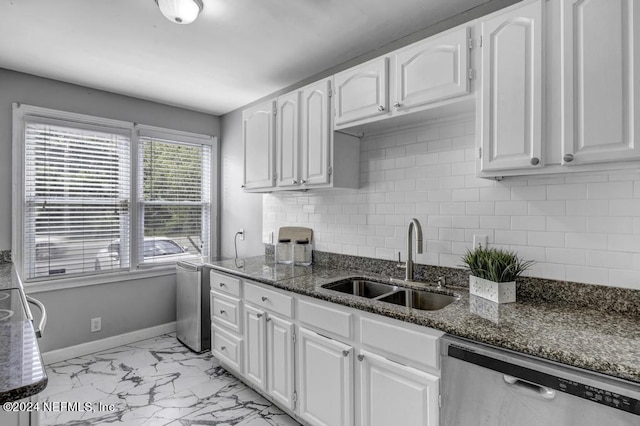 kitchen with baseboards, marble finish floor, stainless steel dishwasher, white cabinetry, and a sink