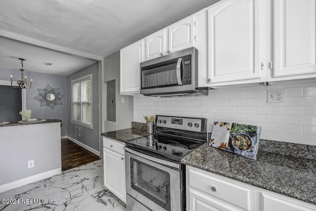 kitchen featuring baseboards, white cabinets, marble finish floor, appliances with stainless steel finishes, and dark stone countertops