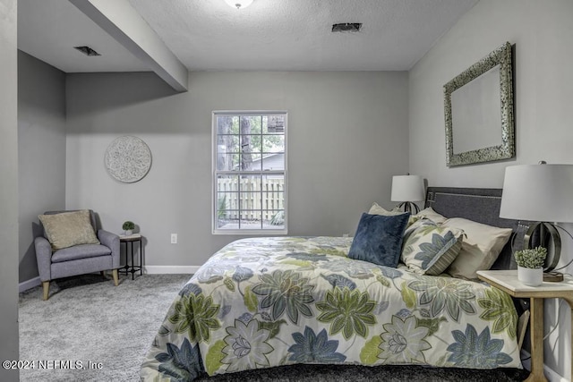 carpeted bedroom featuring visible vents, a textured ceiling, and baseboards