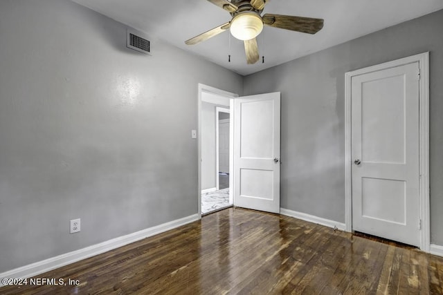 spare room featuring ceiling fan, wood finished floors, visible vents, and baseboards