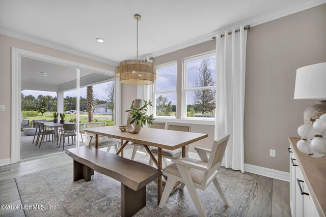 dining room with light wood-type flooring and ornamental molding