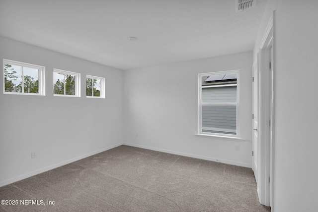 spare room featuring visible vents, baseboards, and carpet