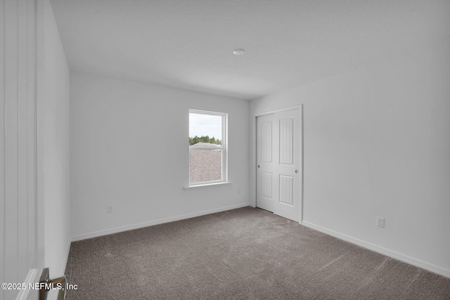 unfurnished room featuring baseboards and carpet floors