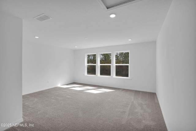 carpeted empty room featuring visible vents, recessed lighting, and baseboards