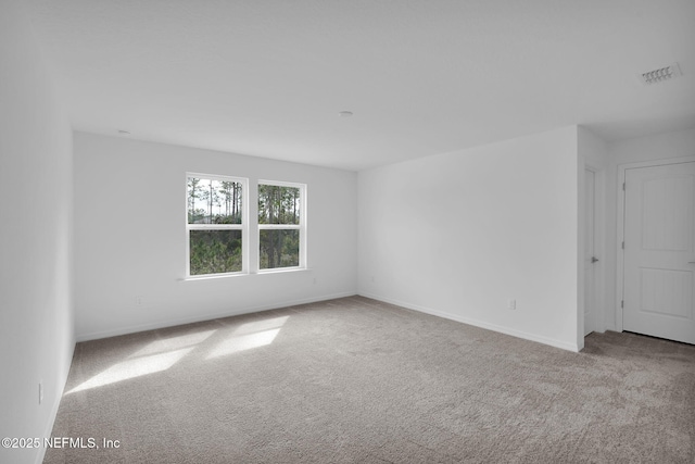 empty room with visible vents, baseboards, and carpet