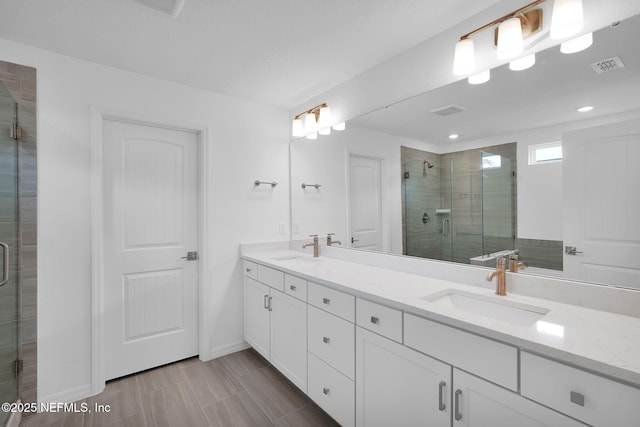 bathroom featuring a sink, double vanity, and a shower stall