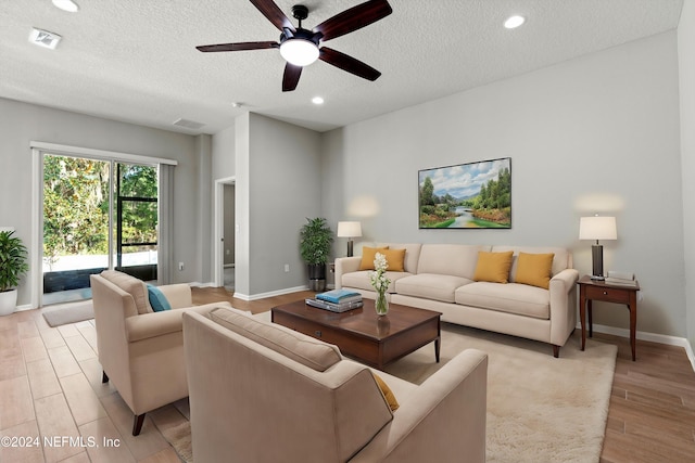 living room featuring a textured ceiling, light hardwood / wood-style floors, and ceiling fan