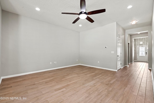 spare room featuring ceiling fan, light hardwood / wood-style floors, and a textured ceiling