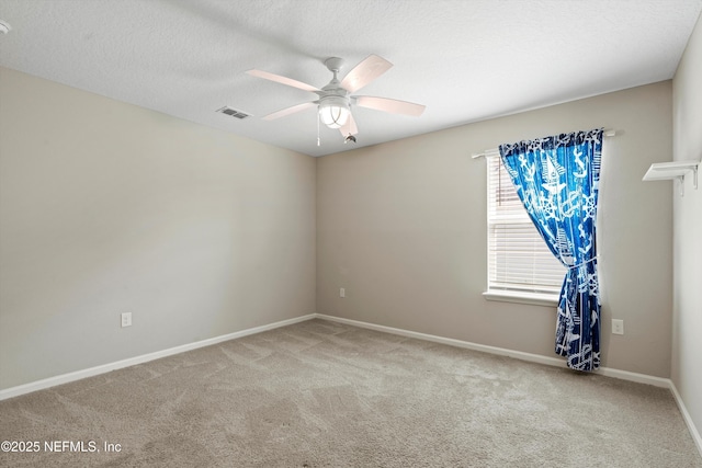 carpeted spare room with a textured ceiling and ceiling fan