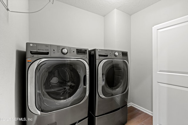 laundry room featuring a textured ceiling and washer and clothes dryer