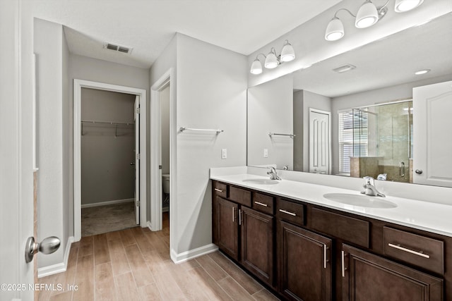 bathroom with vanity, toilet, and a shower with shower door