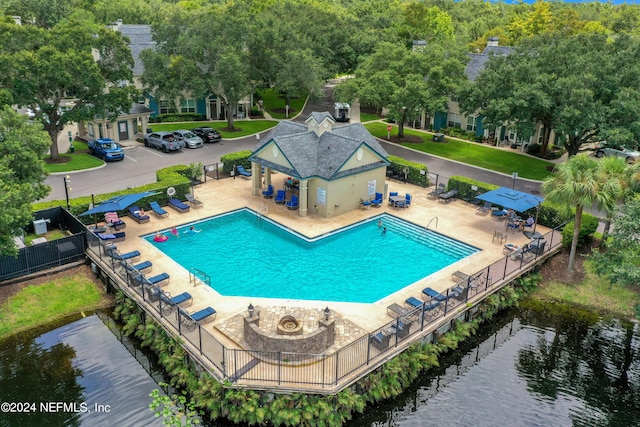 view of swimming pool with a water view and a patio area