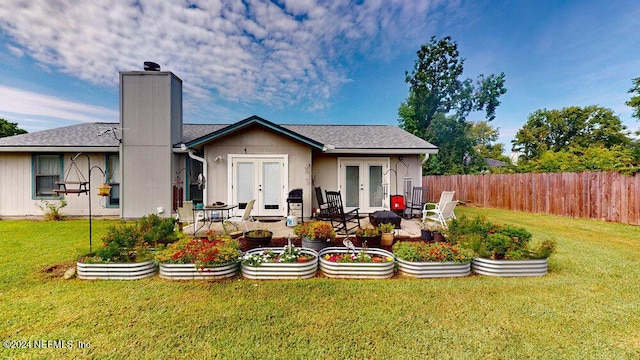 rear view of house featuring a patio, a lawn, and french doors