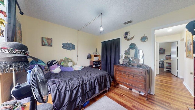 bedroom featuring hardwood / wood-style floors and a textured ceiling