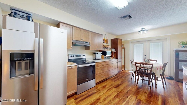 kitchen with hardwood / wood-style flooring, stainless steel appliances, a textured ceiling, light brown cabinetry, and french doors