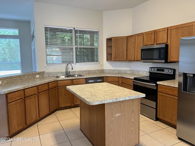 kitchen with light tile patterned floors, a healthy amount of sunlight, appliances with stainless steel finishes, and sink