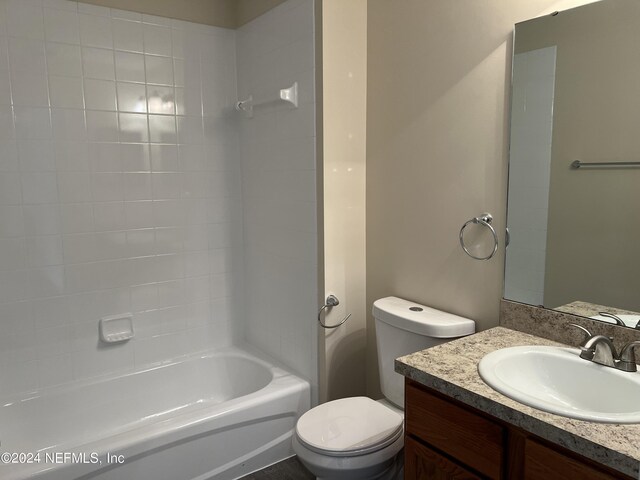 full bathroom featuring vanity, tiled shower / bath combo, and toilet