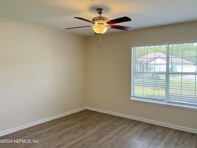 unfurnished room featuring hardwood / wood-style floors, a textured ceiling, ceiling fan, and a wealth of natural light