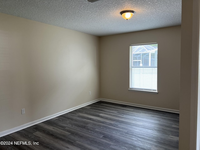 empty room with hardwood / wood-style floors and a textured ceiling