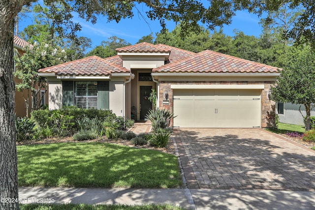 mediterranean / spanish house with a front yard and a garage