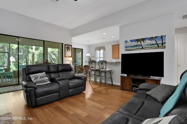 living room featuring a chandelier and light wood-type flooring