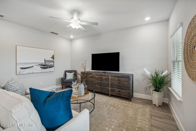 living room with ceiling fan and light wood-type flooring