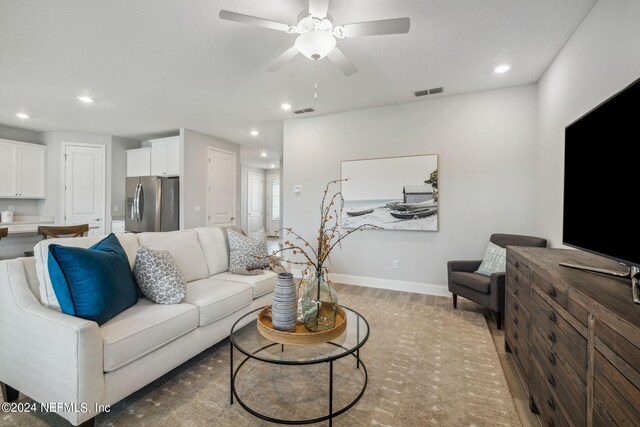 living room with light wood-type flooring and ceiling fan