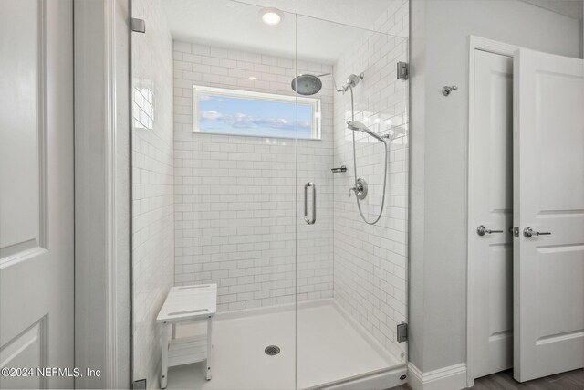 bathroom with hardwood / wood-style floors and a shower with door