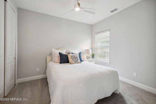 carpeted bedroom featuring ceiling fan and a closet