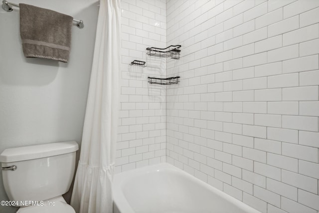 bathroom with shower / bathtub combination with curtain and toilet