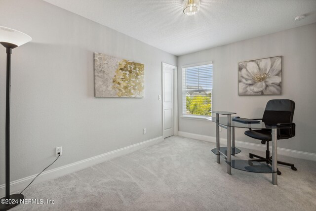 carpeted home office with a textured ceiling