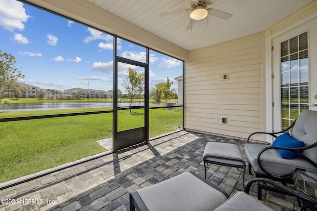 unfurnished sunroom with a water view and ceiling fan