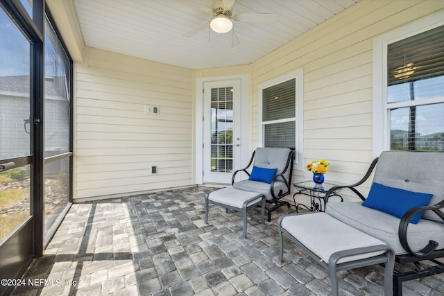 sunroom / solarium featuring plenty of natural light and ceiling fan