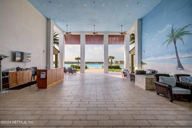 view of patio / terrace with a water view, ceiling fan, and an outdoor kitchen