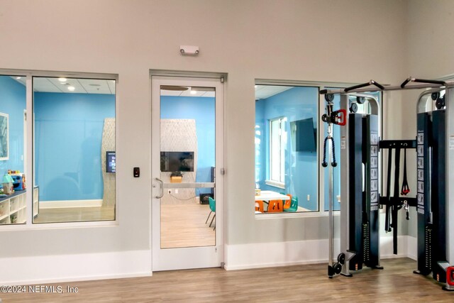 exercise room with light hardwood / wood-style floors