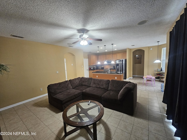 2727 Wood Stork Trl, Orange Park, FL 32073 - living room featuring baseboards, visible vents, light tile patterned flooring, arched walkways, and ceiling fan