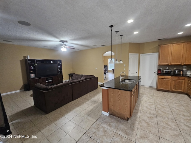 2727 Wood Stork Trl, Orange Park, FL 32073 - kitchen with tasteful backsplash, brown cabinets, arched walkways, a ceiling fan, and a sink