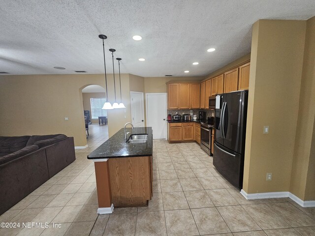 kitchen with stainless steel appliances, sink, decorative light fixtures, a textured ceiling, and light tile patterned flooring