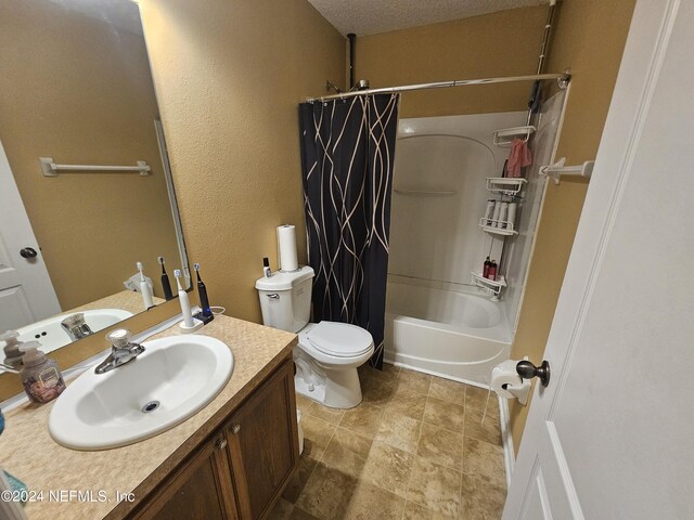 full bathroom featuring shower / tub combo with curtain, vanity, toilet, a textured ceiling, and tile patterned flooring