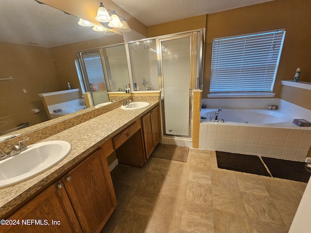 bathroom with double vanity, tile patterned flooring, independent shower and bath, and a textured ceiling