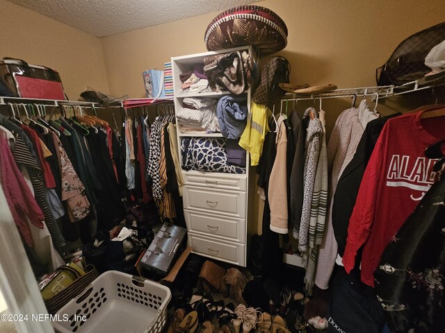 walk in closet featuring dark carpet