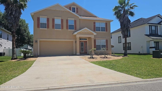 2727 Wood Stork Trl, Orange Park, FL 32073 - view of front of house with concrete driveway, central AC, a front yard, stucco siding, and an attached garage