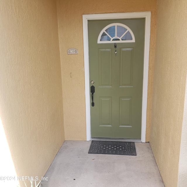 property entrance with stucco siding