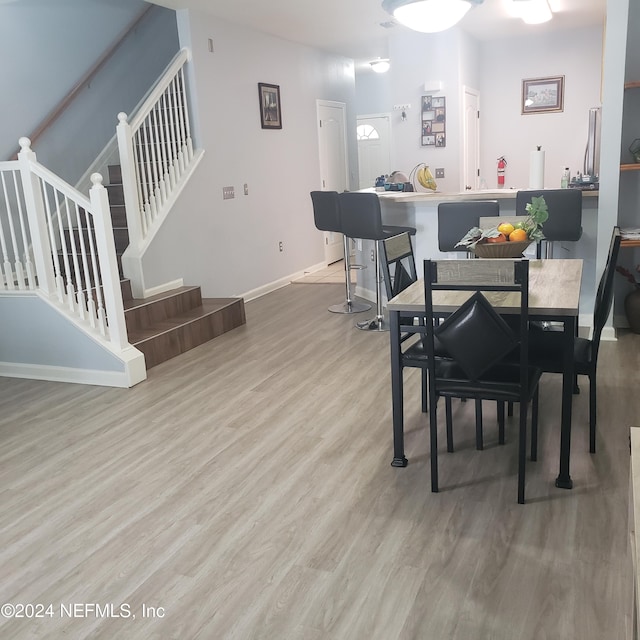 dining room featuring stairs, baseboards, and wood finished floors