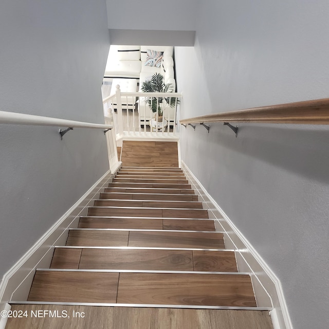 stairs featuring wood finished floors and baseboards