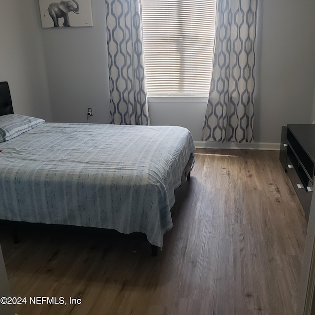 bedroom featuring wood finished floors and baseboards