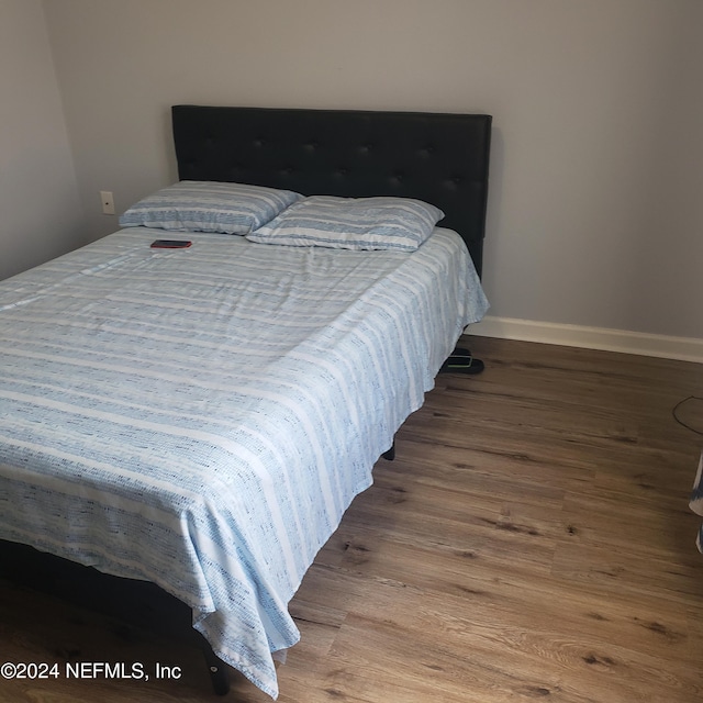 bedroom with baseboards and wood finished floors